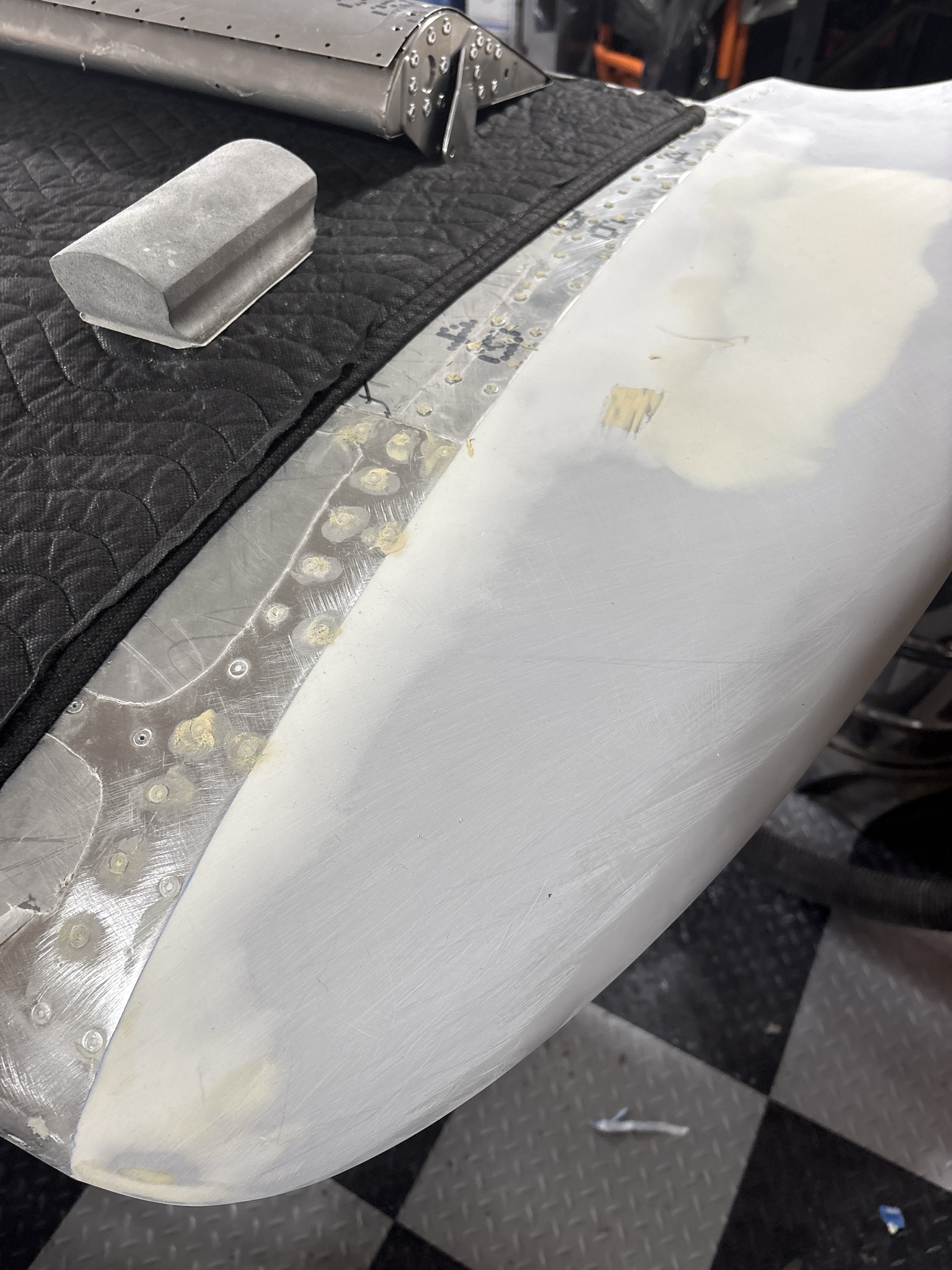 Filling rivets and the window across the top half of the left wing before primer.